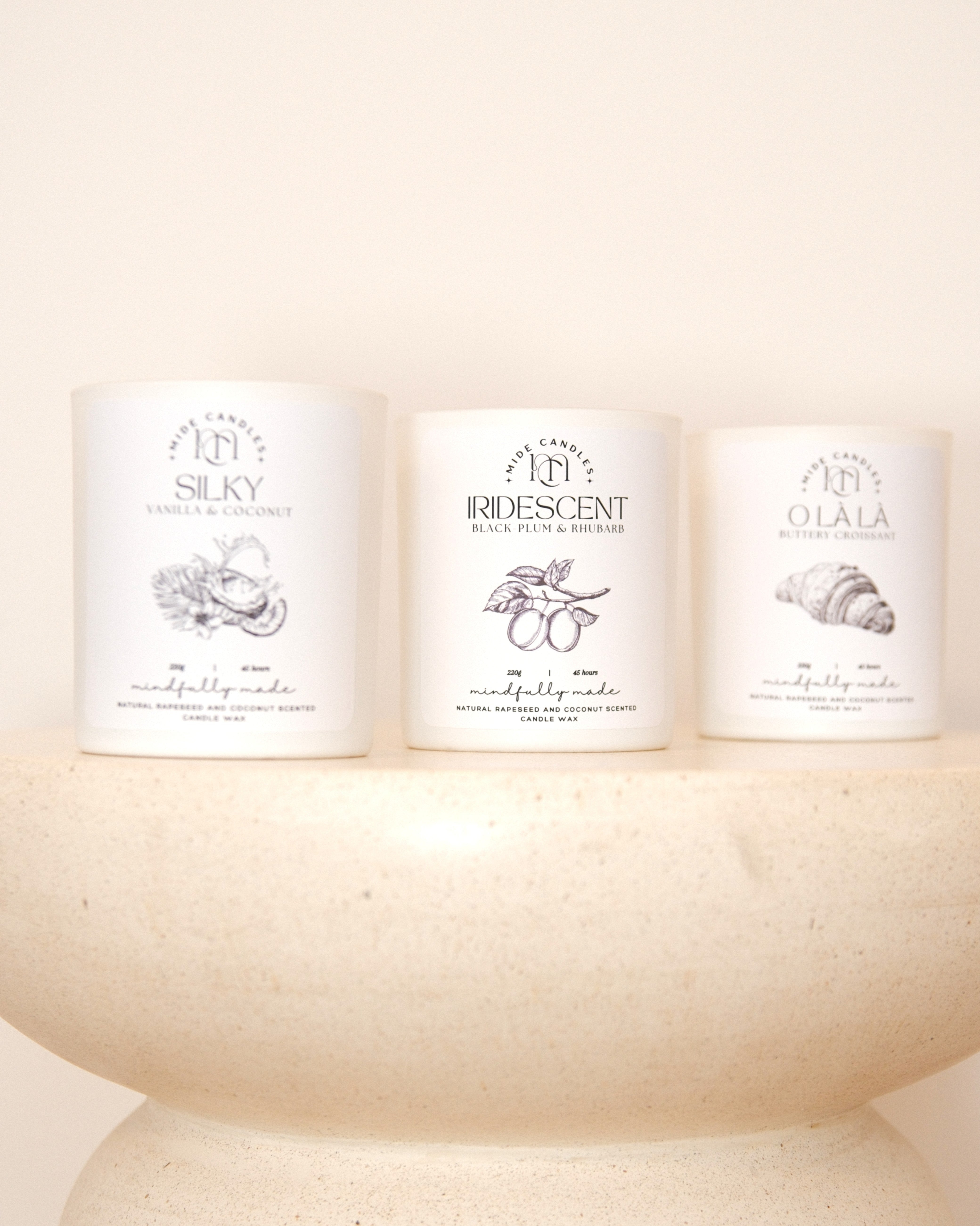 Three candles with labels on a white surface
